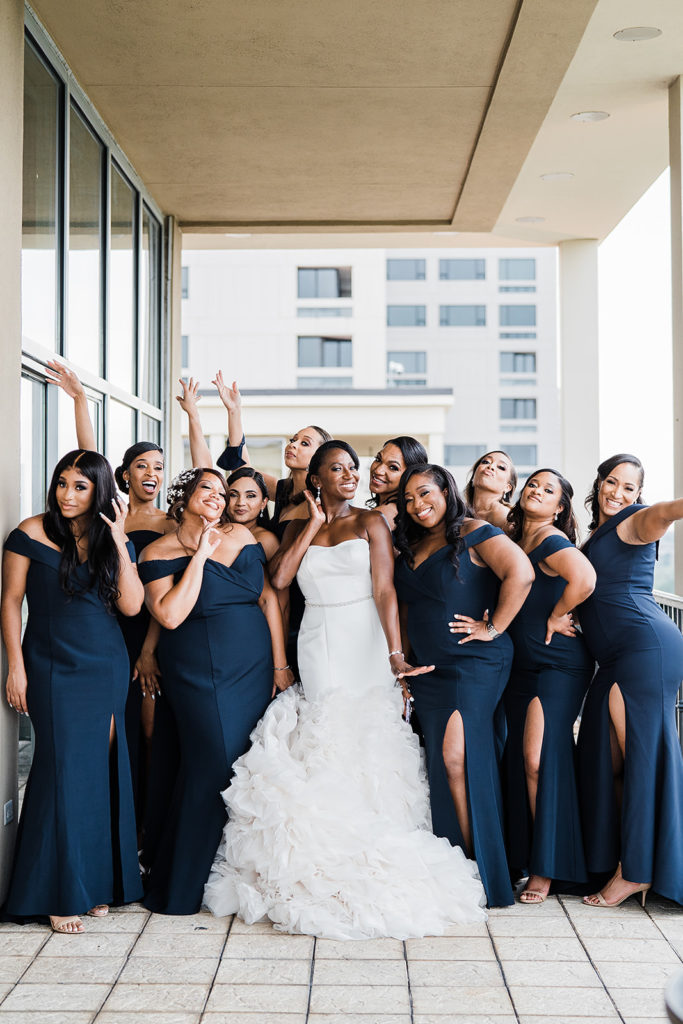 Bridal party navy dresses different skin tones posing 