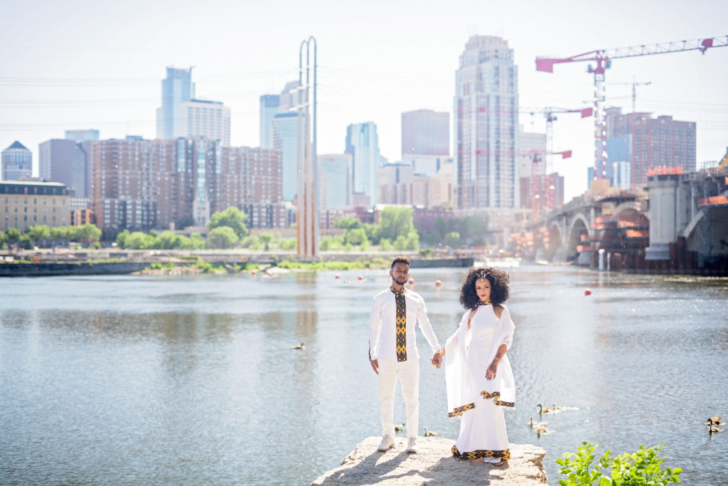 traditional Ethiopian wedding couple in traditional dress holding hands in front of St. Paul Minesota Cityscape