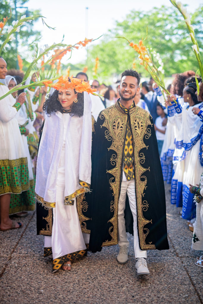 Bride and groom entrance with ethiopian traditional garments welcomed with waving palms ethiopian wedding minnesota