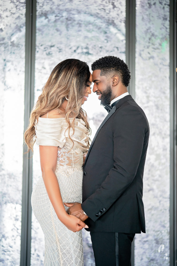 Retro Hollywood Glamor Engagement Session at The Revarie Houston with Black Couple forehead to forehead in high end cream gown and classic black tux