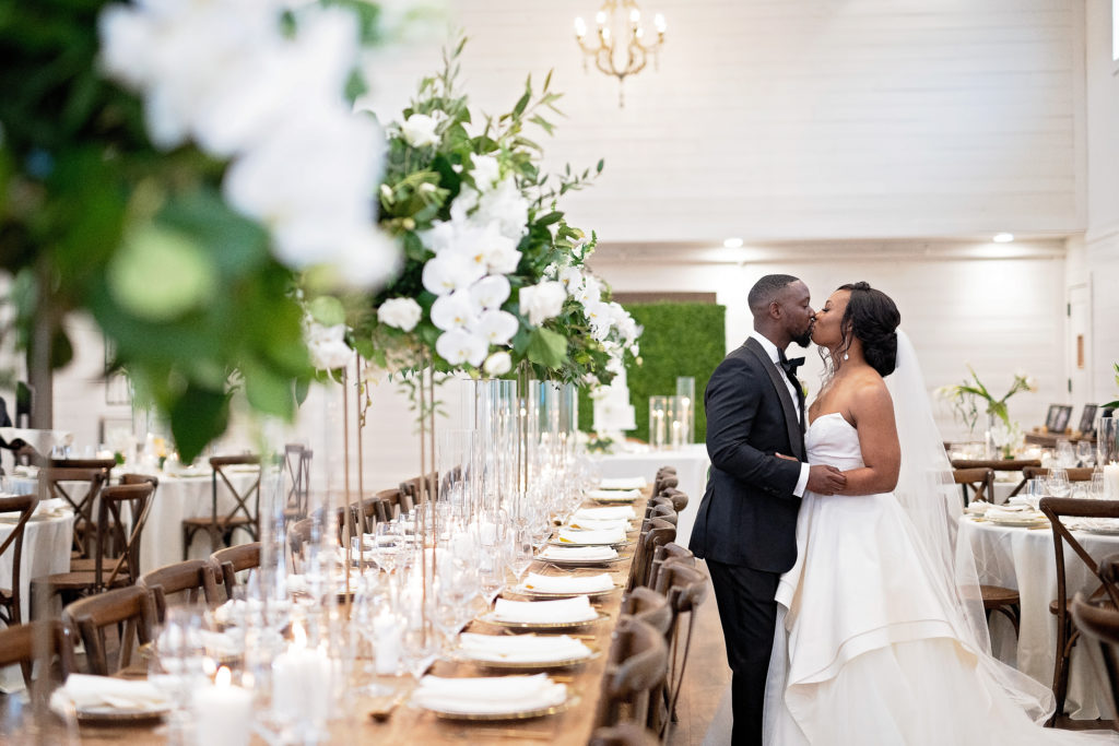 Black couple kissing in reception white, green, brown, natural aesthetic for wedding reception HighPointe Estate wedding Houston Texas 
