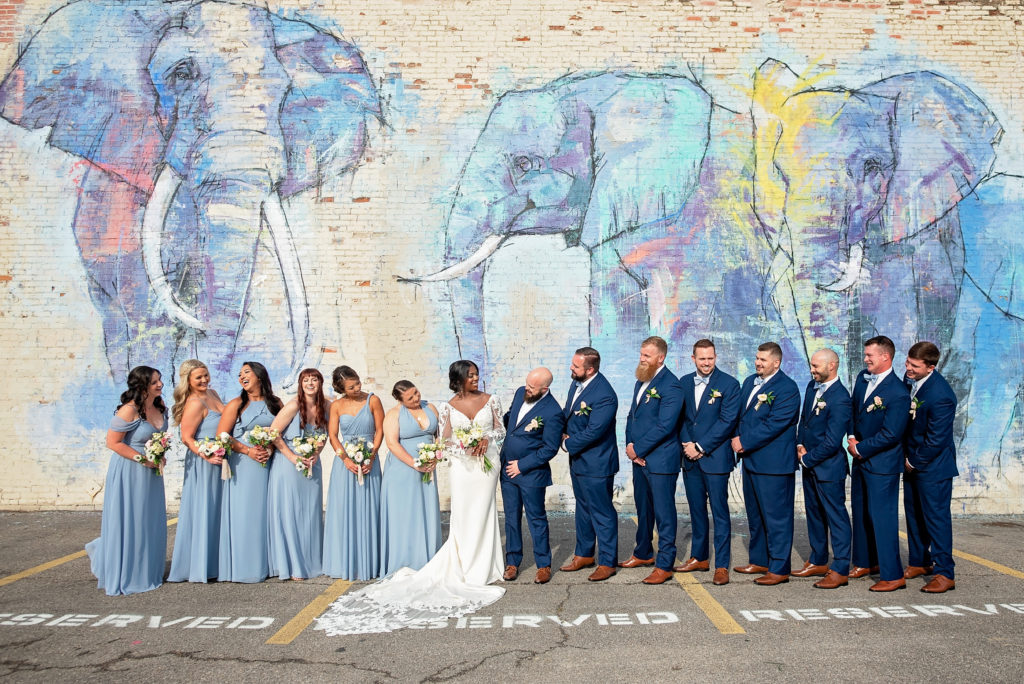 wedding party photo in front of graffiti wall of elephants